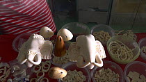 Products made of elephant ivory, including elephant head statuettes, for sale in a shop, Nakhon Sawan, Thailand, 2013.