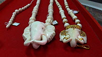 Elephant head necklaces made from elephant ivory for sale in a shop, Nakhon Sawan, Thailand, 2013.