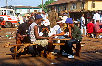 Freetown transport terminal, passengers playing dominoes while waiting. Sierra Leone, 2004-2005.