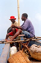 Man with shell to blow to announce departure and arrival on boat journey to Bunce island. Sierra Leone, 2004-2005.