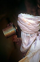 Toubou tribesman drinking water found in rock formation. Northern Niger, 2005.
