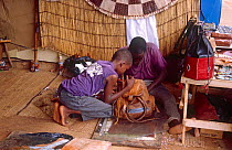 Leather traders repairing bag. Niamey, Niger, 2004.