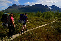 Two teenage girls on hiking trip on the Laponia Circuit, along the Padjelantaleden trail, Padjelanta National Park and Sarek National Park, Norrbotten, Lapland, Sweden. Model released