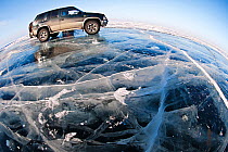 Wide angle view of vehicle parked on ice on lake surface. Lake Baikal, Siberia, Russia, March 2007.