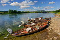 Salmon fishing boats tied up on the banks of Namsen River. Namdalen, Nord-Trondelag, Norway. July.