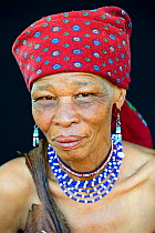 Portrait of Naro San woman wearing traditional clothing and headdress, Kalahari, Ghanzi region, Botswana, Africa. October 2014.