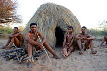Naro San Bushmen sitting in front of their hut, Kalahari, Ghanzi region, Botswana, Africa. Dry season, October 2014.