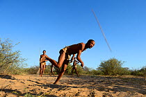 Naro San Bushmen playing game throwing sticks, Kalahari, Ghanzi region, Botswana, Africa. Dry season, October 2014.