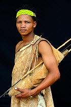 Portrait of Naro San Bushman with bow and arrows and traditional duiker leather clothing. Kalahari, Ghanzi region, Botswana, Africa, October 2014.