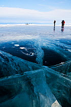 People standing on thick ice on the surface of Lake Baikal, Siberia, Russia, March 2008.