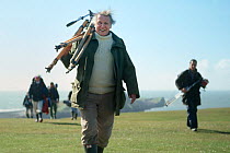 David Attenborough carrying tripod back from a shoot on the Worm's Heads, on production for The Trials of Life. Gower Peninsula, Wales, UK, 1988. Small reproduction only.