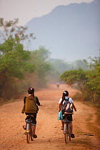 Children cycling to school, near Vang Vieng, Laos, March 2009.