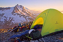 Photographer's tent pitched on top of Ruth Mountain at sunset, with a view of Mount Shuksan and Mount Baker just about visible beyond, North Cascades, Washington, USA, July 2014.