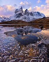 Cuernos del Paine reflected in icy lake at dawn, Torres del Paine National Park, Chile, June 2014.