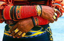 Close up of a Guna/Kuna Indian woman's traditional arm decorations and gold rings, San Blas Islands, Panama.