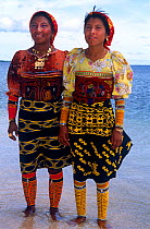 Guna/Kuna Indian women in traditional clothing wearing arm decorations and Mola Mola blouses and gold rings, San Blas Islands, Panama.