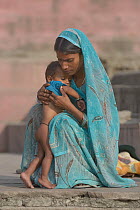 Woman wearing sari embracing child, Varanasi, Uttah Pradesh, India, March 2014.