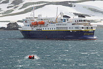 Zodiac boat carrying tourists back to the expedition ship 'National Geographic Explorer' over a rough sea in the bay of Half Moon Island, South Shetland Islands group, Antarctica, February 2011.