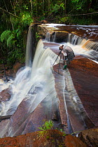 Photographer at Giluk Falls, edge of the southern plateau. Maliau Basin, Sabah, Borneo, May 2011.