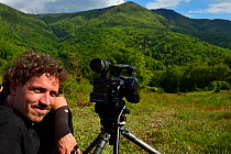 Kristjan Jung, Communications Manager at Rewilding Europe, filming European bison / Wisent (Bison bonasus) released into the Tarcu mountains nature reserve, Natura 2000 area, Southern Carpathians, Rom...