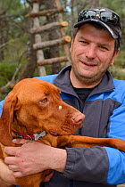 Lagosta hunting club member with dog during work on Dolin island, Velebit Mountains Nature Park, Croatia, April 2014.