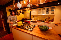Woman preparing soup in kitchen of Linden Tree Retreat & Ranch, Mejida, Velika Plana, Velebit Mountains Nature Park, Croatia, April 2014.