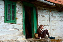 Woman sat writing outside Linden Tree Retreat & Ranch, Velika Plana, Velebit Mountains Nature Park, Croatia, April 2014.