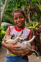 Local girl holding sleeping puppy, Kioa Island, Fiji, South Pacific, July 2014.