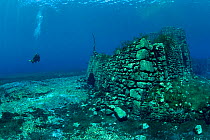 Scuba diver with remains of submerged mill, Lago di Capo D'Acqua, Capestrano, Aquila, Abruzzo, Italy, May 2006.