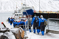 Tourists boarding commercial whale-watching boat, Grundarfjordur, Iceland, March 2014.