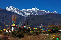 Prayer flags attatched to cairn, Mount Kawakarpo, Meili Snow Mountain National Park, Yunnan Province, China. October 2009