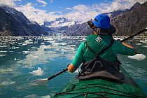 Kayaker paddles between ice, Johns Hopkins Inle, Glacier Bay National Park, Alaska, Model released