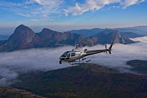 Aerial view of  Mount Namuli with helicopter with ciniflex flying in front, Mozambique, May 2011.