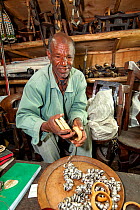 Interior of a tourist shop in Addis Ababa, with merchant selling ivory bracelets which the merchant claimed was antique from before anti-poaching laws. Addis Ababa / Abeba, Ethiopia. February 2009