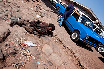 Homeless beggar lies on the floor next to a taxi stand in Addis Mercato, Addis Ababa, Ethiopia. February 2009