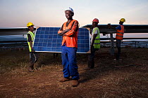 Technicians installing panels in one of East Africa's largest Solar farms, Rwamagana District, Rwanda. July 2014. Model released.