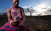 Maasai man using mobile phone, Mara region, Kenya, September 2013.