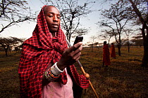 Maasai man using mobile phone, Mara region, Kenya, September 2013.