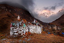 Mani wall (or Chorten) at Camp Jangothang with Mount Jhomolhari, distance. Jhomolhari Trek. Bhutan, October 2014.