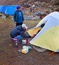 Morning tea served to trekking clients at Camp Jangothang on the Jhomolhari Trek.  Bhutan, October 2014. Model released.