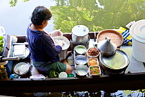 Woman preparing food in boat at the Ladmayom Floating Market near Bangkok. Thailand, September 2014.