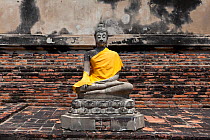 Statue of Buddha (in Calling the Earth to Witness posture) with yellow sash, at Wat Yai Chaya Mongkol, Ayutthaya, Thailand, September 2014.