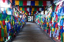 Prayer flags covering the side of Kuendeying Bazzam Bridge over the Wang Chhu, Thimphu. Bhutan, October 2014.