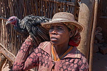 Woman carrying turkey, Ambalavao, Madagascar. November 2014.