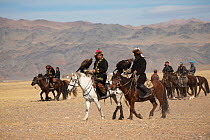 Eagle hunters mounted on Mongolian horses arrive with their female Golden eagles (Aquila chrysaetos) to compete at the Eagle Hunters Festival, near Sagsai, Bayan-Ulgii Aymag, Mongolia. September 2014....