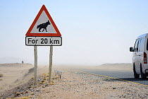 Traffic sign warning of brown hyaena (Hyaena brunnea) crossing, Luderitz, Namib desert, Namibia, November.