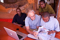 Iain Douglas-Hamilton and Save the Elephants team looking at Save the Elephants database and files, Kenya. Model released