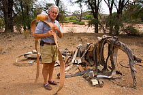 Iain Douglas-Hamilton with various elephant radio tracking collars used by Save the Elephants, Samburu National Reserve, Kenya. Model Released