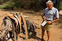 Iain Douglas-Hamilton with various elephant radio tracking collars used by Save the Elephants, Samburu National Reserve, Kenya. Model Released
