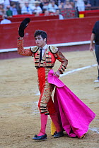 Torero / Bullfighter in traditional costume, holding magneta cape used in the first round (Tercio) of the bullfight, Tercio de Varas. Plaza de Toros, Valencia, Spain. July 2014.